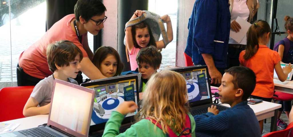 Enfants autour d'une table travaillant sur ordinateur